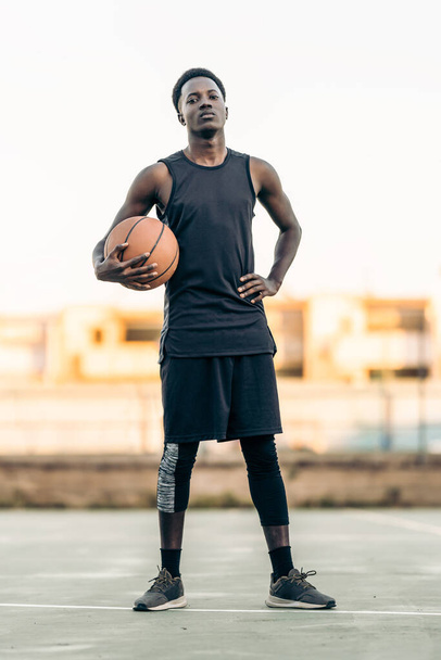Portrait of a proud african man with a basketball - 写真・画像