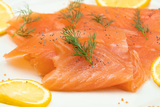 slices of smoked salmon and lemon slices on a plate - Fotoğraf, Görsel
