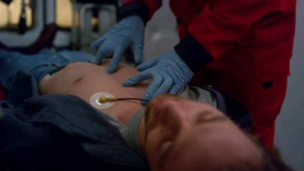 Ambulance mains paramédicales effectuant un massage cardiaque de l'homme blessé - Séquence, vidéo