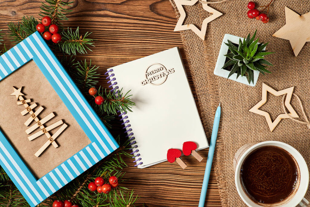 Noel kompozisyonu boş not defteri, kahve fincanı, Noel ağacı ve tahta arka planda kaktüs. - Fotoğraf, Görsel