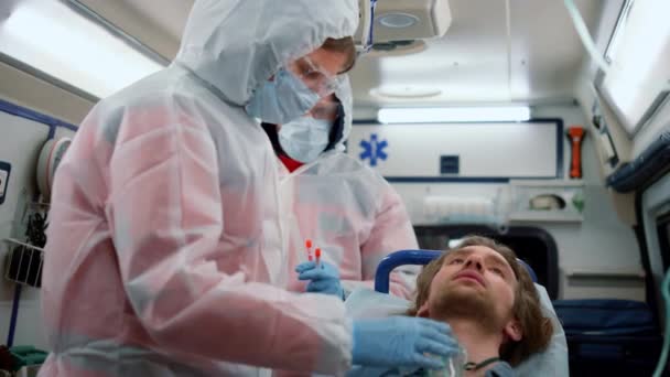 Pohotovostní lékaři poskytující první pomoc pacientovi v sanitním autě - Záběry, video