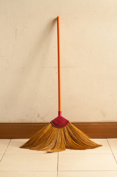 broom leaning on the old gray wall - Фото, изображение