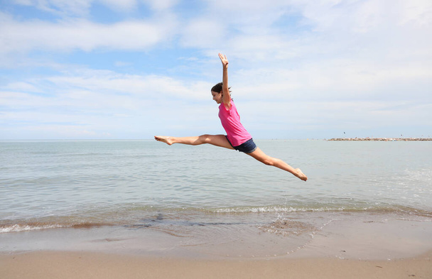 Kavkazská dívka provádějící obtížná rytmická gymnastická cvičení a rozdělení ve vzduchu - Fotografie, Obrázek
