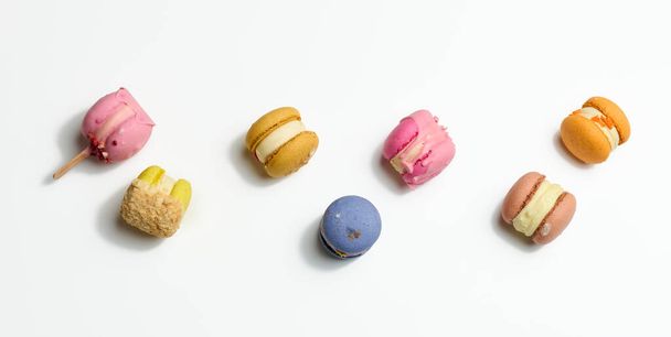 baked macarons with different flavors on a white background, top view - Foto, afbeelding