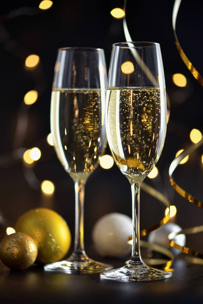 Dos copas de champán y decoraciones navideñas sobre un fondo festivo oscuro. Feliz Año Nuevo. - Foto, Imagen