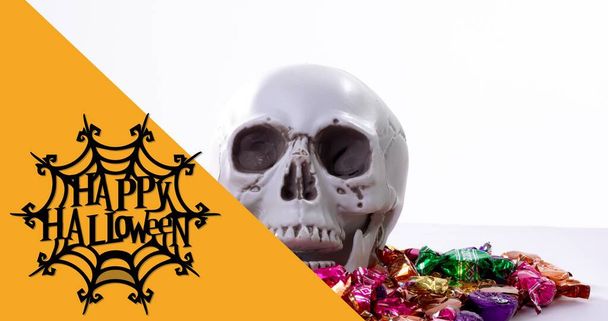Digital composite of happy halloween over spider wen with skull on candies. culture, celebration and horror. - Foto, afbeelding