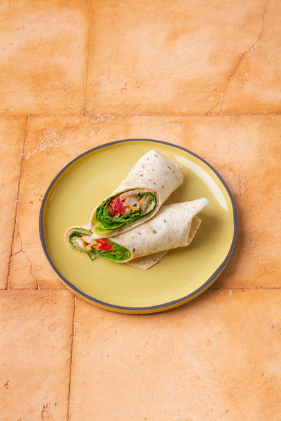 Pair of fresh wrap sandwiches with chicken and vegetables on yellow plate - Valokuva, kuva