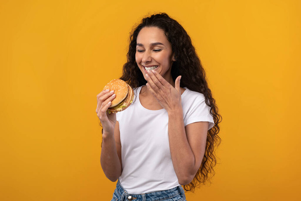Happy Laughing Lady jedzenie hamburgera w studio - Zdjęcie, obraz