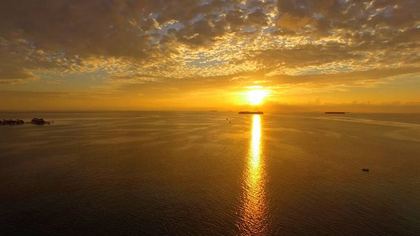 Színes naplemente a Maldív-szigeteken, a távolban látható az üdülőhely szigete - Fotó, kép