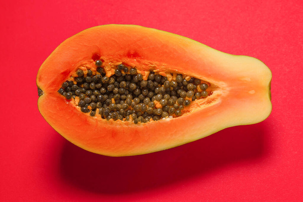 Frutta di papaya su uno sfondo arancione. Frutta tropicale. Mezza papaia.  - Foto, immagini