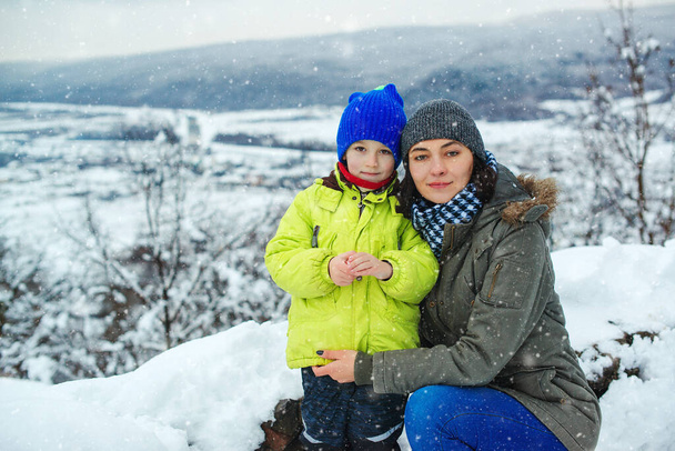 Rodzina ciesząca się piękną zimową przyrodą. Snowy sezon zimowy. Mama i dziecko bawią się razem podczas świąt Bożego Narodzenia. Szczęśliwej rodziny i dzieciństwa. Matka i dziecko na śnieżnym zimowym spacerze. - Zdjęcie, obraz