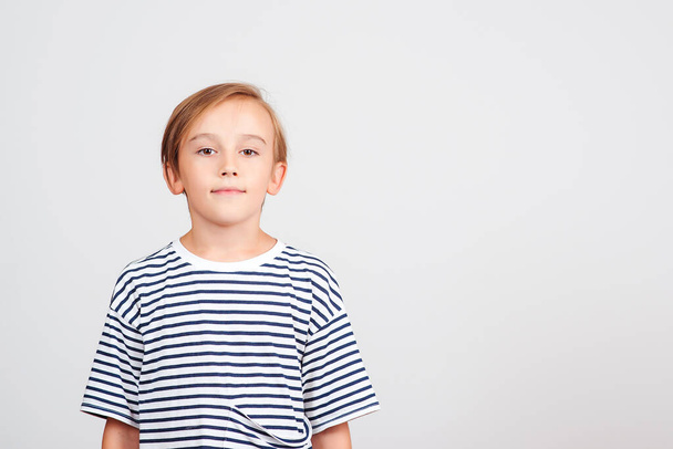 Children style and fashion. Cute boy with stylish hairstyle. Happy childhood and positive emotions. Face expression. Smiling boy posing at studio. Copy space, banner. Boy looking at camera. - Photo, Image