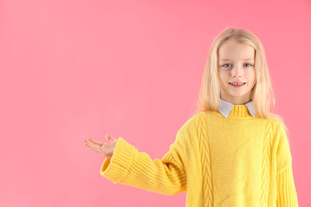 Linda niña en suéter sobre fondo rosa - Foto, Imagen