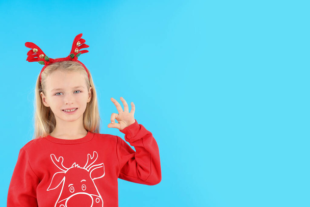 Petite fille en vêtements de Noël sur fond bleu - Photo, image