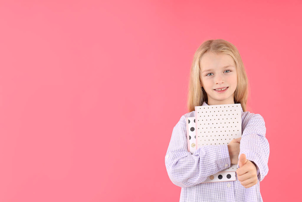 Linda niña con cuadernos sobre fondo rosa - Foto, Imagen