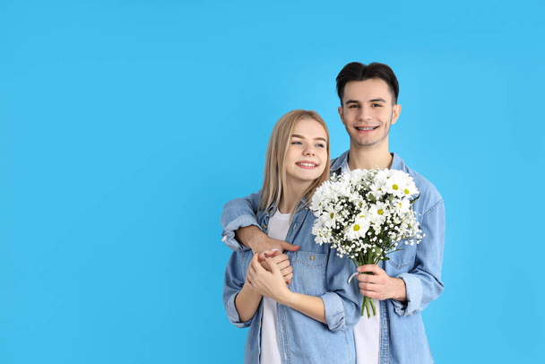 Cute couple with bouquet on blue background - Zdjęcie, obraz