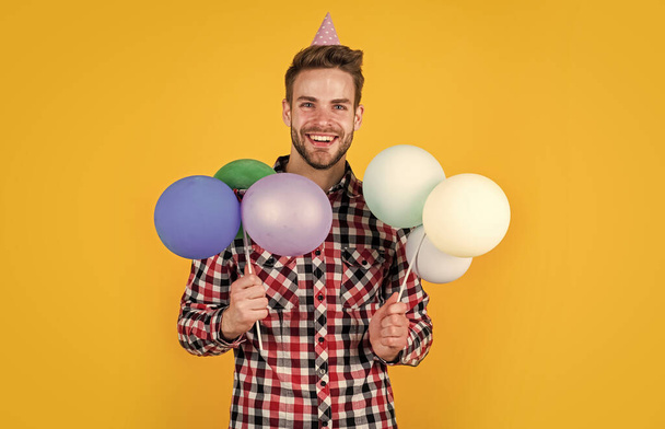 bearded man with bristle hold balloons. preparation and celebration. party fun. shopping sale. happy birthday guy in checkered shirt. stylish male with holiday accessory - Foto, imagen