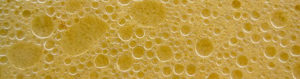 水の表面に気泡。水系乳剤の脂肪環。泡のついた黄色の液体。サイトに挿入するためのバナー - 写真・画像