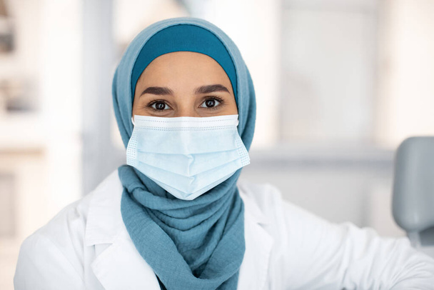 Portrait Of Muslim Female Medical Worker In Hijab And Protective Face Mask - Fotografie, Obrázek
