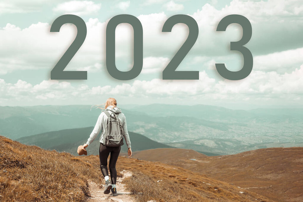 Neujahrskonzept für 2023. Frau wandert am Gipfel des Berges - Foto, Bild