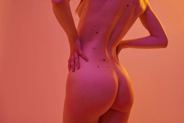 Back view of nude sexy girl with hands on hips - Foto, afbeelding