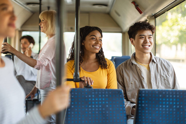 Joven asiático chico y negro dama tomando autobús juntos - Foto, Imagen