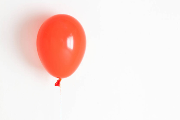 Red balloon. Red festive, joyful balloon on a string.  - Fotó, kép