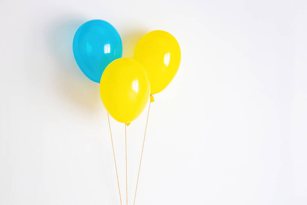 Yellow with blue balloon. Yellow and blue festive, joyful balloon on a string.  - Fotó, kép