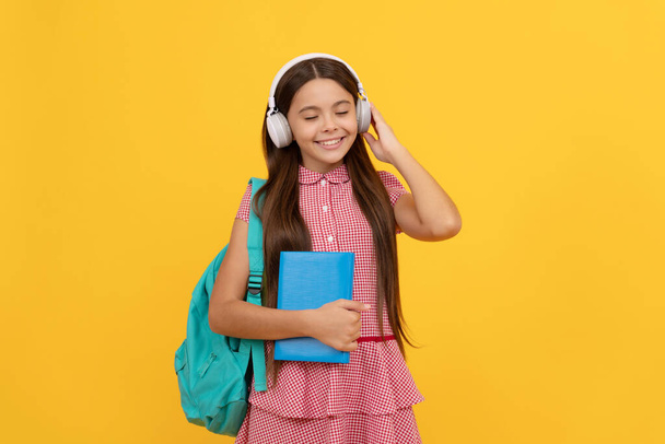 Veselé dítě se školní taškou. hudba. dospívající dívka nosit batoh. zpět do školy. - Fotografie, Obrázek