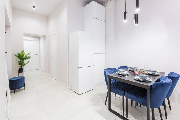 Innenraum einer kleinen, hellen Küche in einer kleinen, modernen Wohnung mit weißen Wänden - Foto, Bild