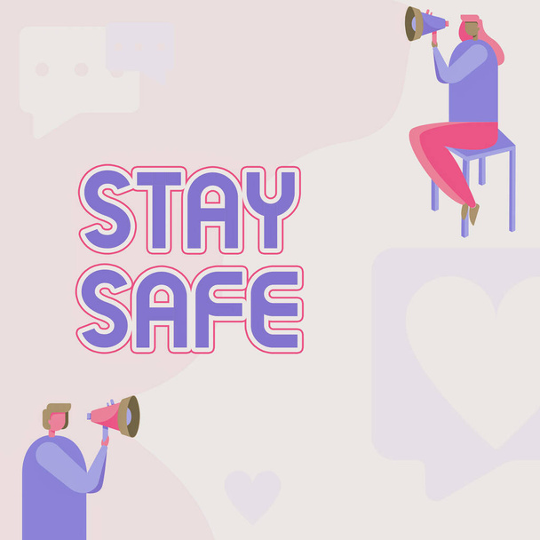 Schild mit der Aufschrift Stay Safe. Konzeptfoto sicher vor Gefahr, Schaden oder Ort, an dem Artikel aufbewahrt werden können Mann stehend und Frau sitzend, beide mit Megafon mit Botschaftssymbol. - Foto, Bild