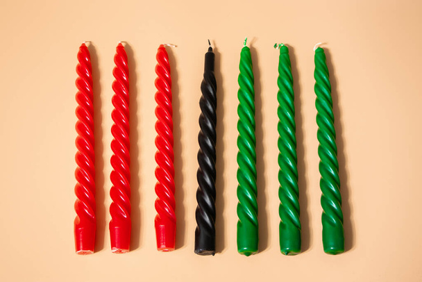 Kwanzaa Americká oslava. Sedm červených, černých a zelených svíček na přirozeném béžovém pozadí. Symboly afrického dědictví. - Fotografie, Obrázek