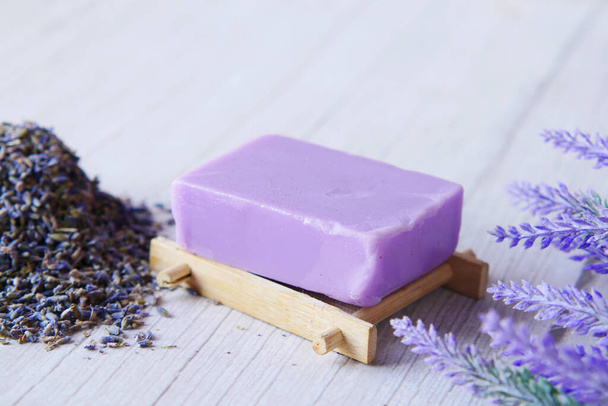 Barra de jabón natural casera y flor de lavanda sobre fondo púrpura  - Foto, Imagen