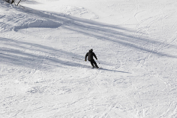 Skier on ski slope at sun winter day. Caucasus Mountains. Hatsvali, Svaneti region of Georgia. - Photo, image