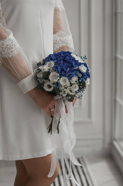 Wedding couple holding hands and holding bridal flower - Foto, imagen