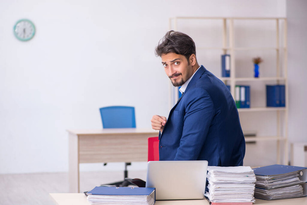 Jeune employé masculin et trop de travail au bureau - Photo, image