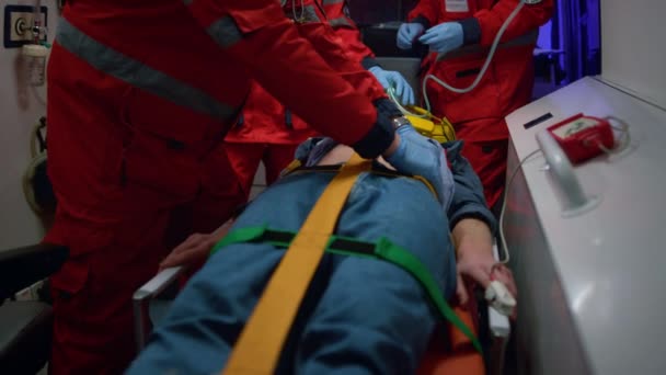 Paramedici geven eerste hulp aan patiënten in ambulancewagens. Dokter onderzoeksman  - Video