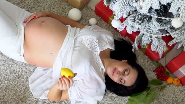bella donna incinta si trova vicino all'albero di Natale nuovo anno - Filmati, video