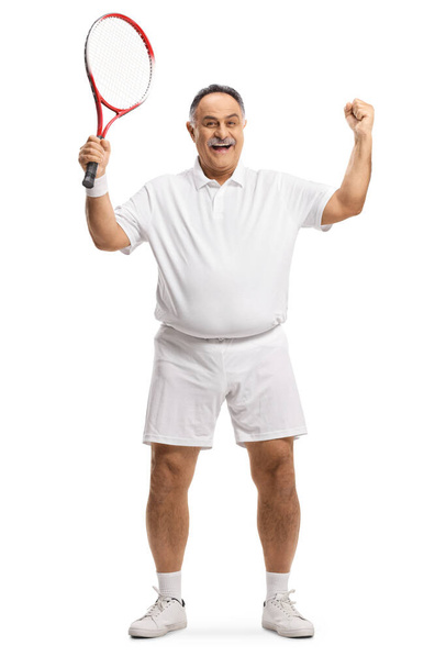 Full length portrait of a mature man with a tennis racket gesturing win isolated on white background - Foto, Bild