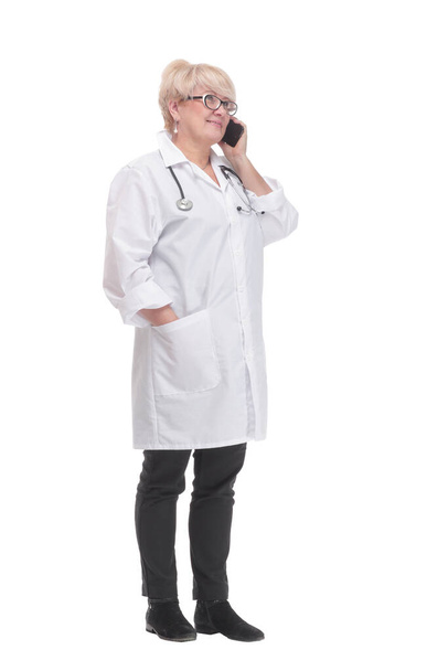 full-length.competent doctor with a smartphone. isolated on a white - Φωτογραφία, εικόνα