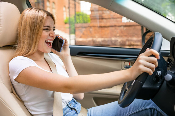 вид збоку усміхненої жінки за кермом автомобіля і розмовами на смартфоні
 - Фото, зображення