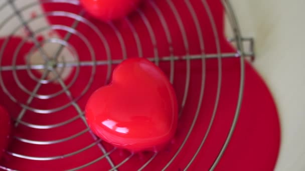 Γλασαρισμένα κέικ σε σχήμα καρδιάς βρίσκονται σε ένα μεταλλικό στήριγμα στο τραπέζι - Πλάνα, βίντεο