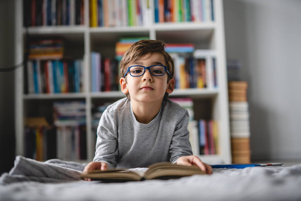 Kafkasyalı bir çocuk bütün gün evde yerde yatıp kitap okuyordu. - Fotoğraf, Görsel