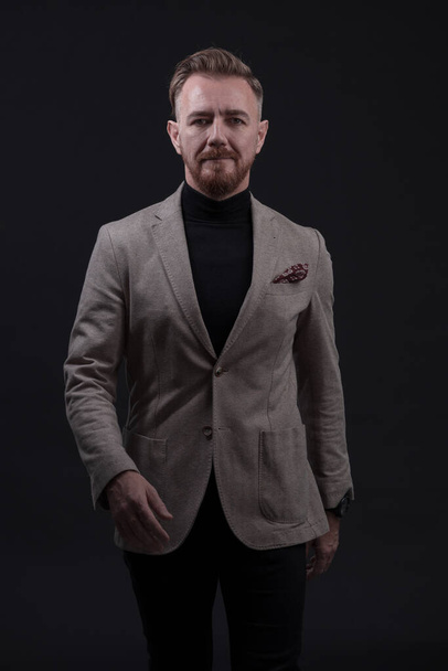 Confident businessman walking forward wearing a causal suit, handsome senior business man hero shot portrait isolated on black. High quality photo - Foto, afbeelding