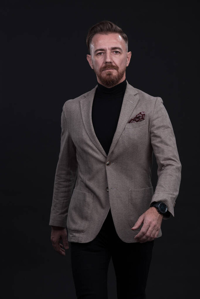 Confident businessman walking forward wearing a causal suit, handsome senior business man hero shot portrait isolated on black. High quality photo - Foto, Imagen
