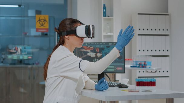 Laboratoriummedewerker met een bril met 3D projectie in het laboratorium - Foto, afbeelding