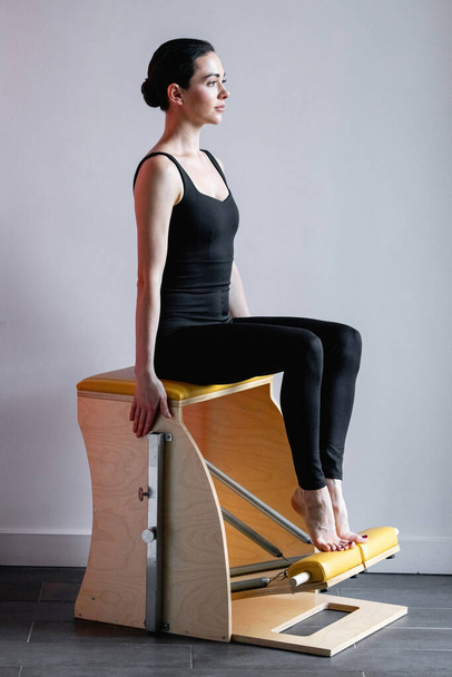 Pilates reformer chair woman fitness yoga gym exercise. Correction of musculoskeletal system, beautiful body. - Φωτογραφία, εικόνα