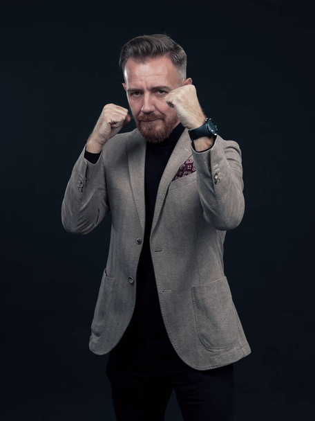 Portrait of a stylish elegant senior businessman with a beard and casual business clothes ready to fight hands gesture - Fotografie, Obrázek