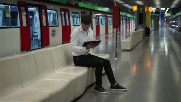 Άνδρας επιβάτης που χρησιμοποιεί tablet στον υπόγειο σταθμό - Πλάνα, βίντεο