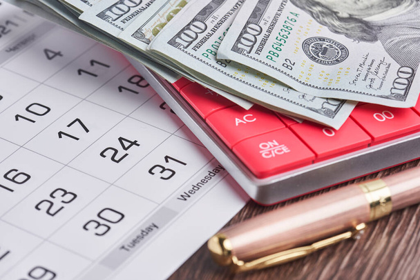 Calculator, us dollars and monthly calendar. Pay day, last day concepts - Photo, Image